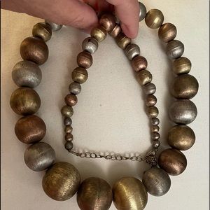 Golden beige tones in colour round beads 1 inch the bottom 1/4 in at neck clasp